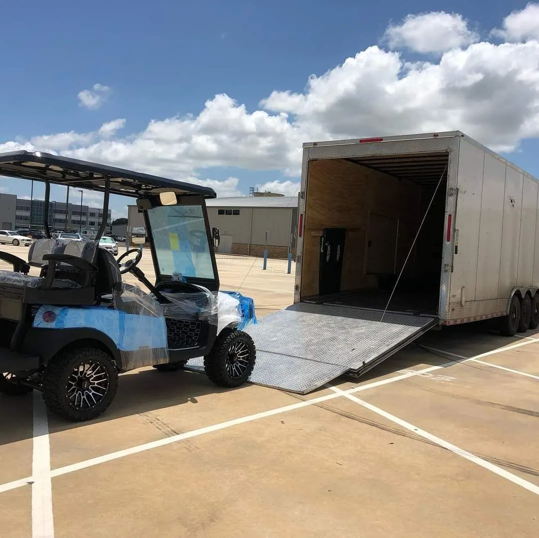 A wrapped, freshly upgraded golf cart being loaded for delivery
